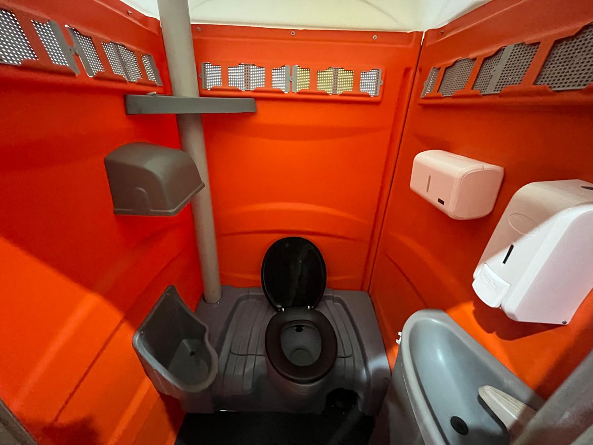 Interior de cabine sanitária limpa, com vaso, mictório, pia e dispensers