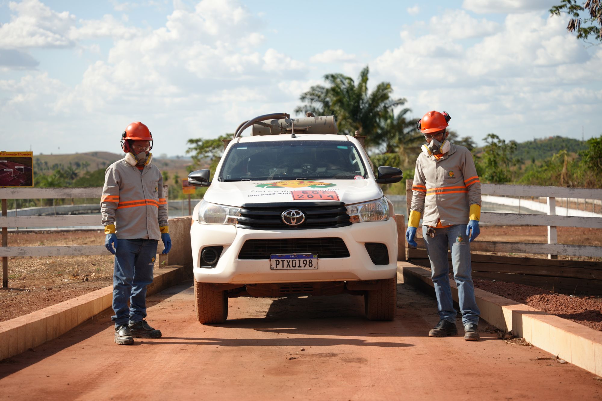 Equipe da LR Service com EPIs ao lado de caminhonete em estação de tratamento de efluentes