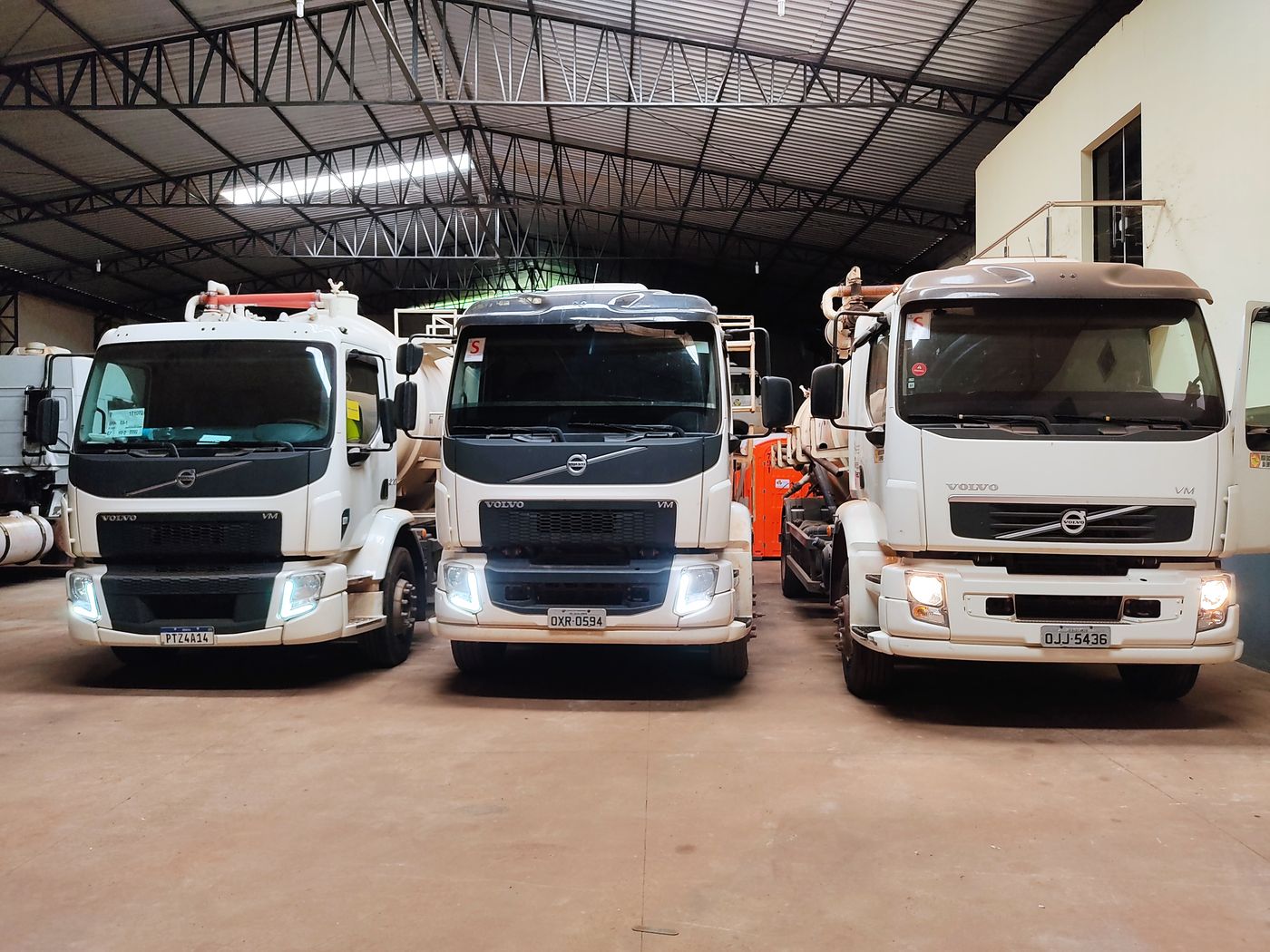 Três caminhões de sucção Volvo da LR Service na garagem da empresa